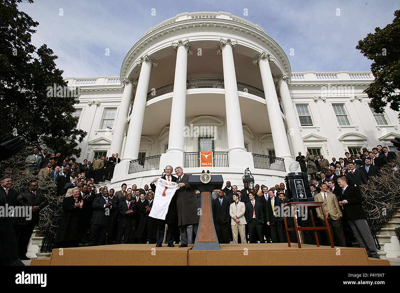 President George W. Bush holds up a University of Texas Longhorns jersey with head football coach Mack Brown, Tuesday, Feb. 14, 2006, during South Lawn ceremonies to honor the 2005 NCAA Football Champions. Stock Photo