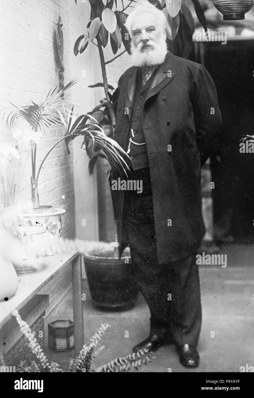 A.G. Bell, standing, among plants Stock Photo