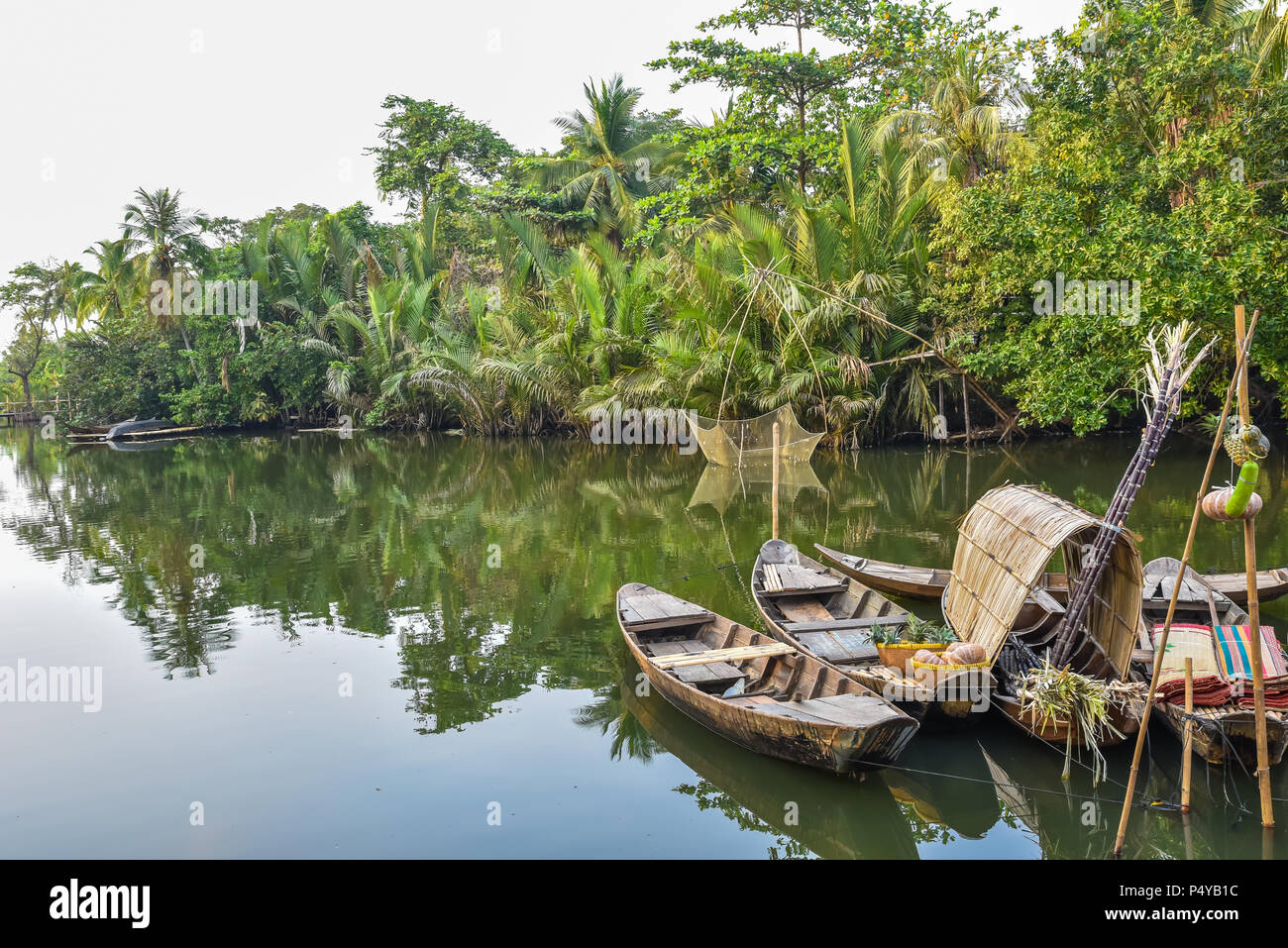 Traditional wooden boat in a small river in the Mekong Delta region of ...