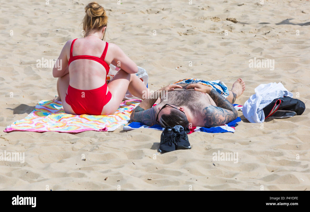 Bournemouth, Dorset, UK. 23rd June 2018. UK weather: crowded beaches on a lovely hot sunny day as visitors head to the seaside to make the most of the sunshine as temperatures rise for the heatwave. Couple sunbathing on the beach - sunbathers sunbather Stock Photo