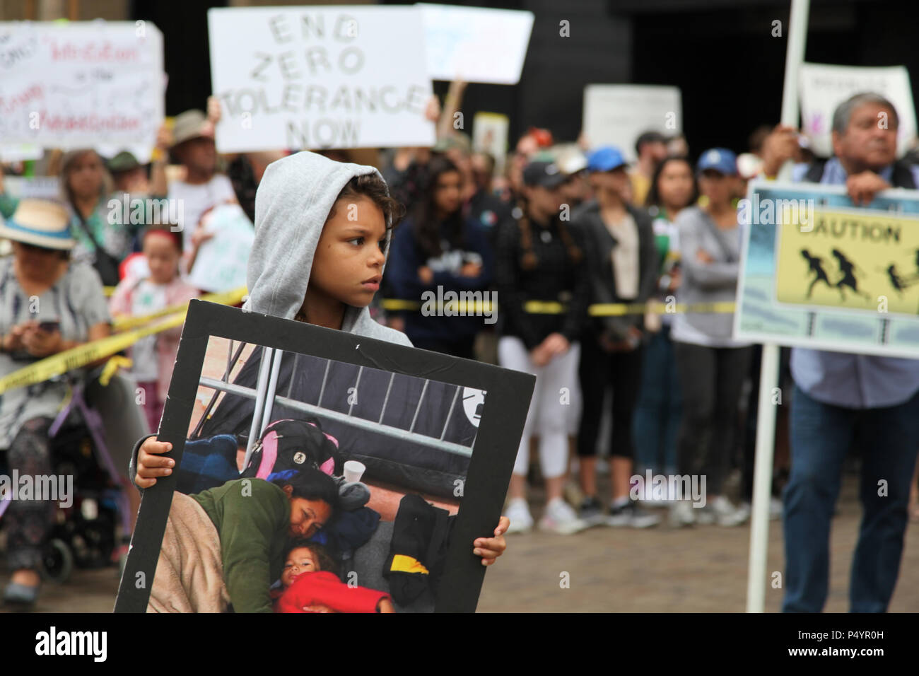 San Diego, USA. 23rd June, 2018. A boy takes part in the 'Families Belong Together' protest in San Diego, the United States, on June 23, 2018. Thousands of people marched in protest in the U.S.-Mexico border city of San Diego on Saturday, raising slogans against the Trump administration's policy of separating children from immigrant parents. Credit: Gao Shan/Xinhua/Alamy Live News Stock Photo