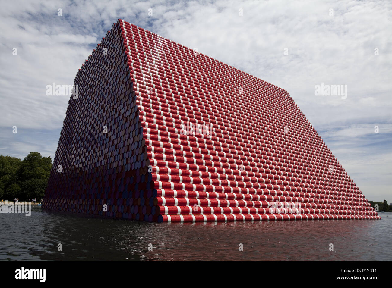 London, UK. 23 June 2018 The Mastaba, a temporary sculpture made of stacked barrels in Serpentine Lake in Hyde Park, is made by one of the world's most celebrated artists, famous for ambitious large scale works. Christo and his late wife Jean-Claude took an inspiration from ancient mastabas (benches) structures that originated in first urban civilisatons of Mesopotamia. Twenty metres in height, the structure consists of 7506 horizontally-stacked coloured barrels. The sculpture coincides with Serpentine Galleries exhibition of Christo and Jeanne-Claude's use of barrels in their work over th Cre Stock Photo