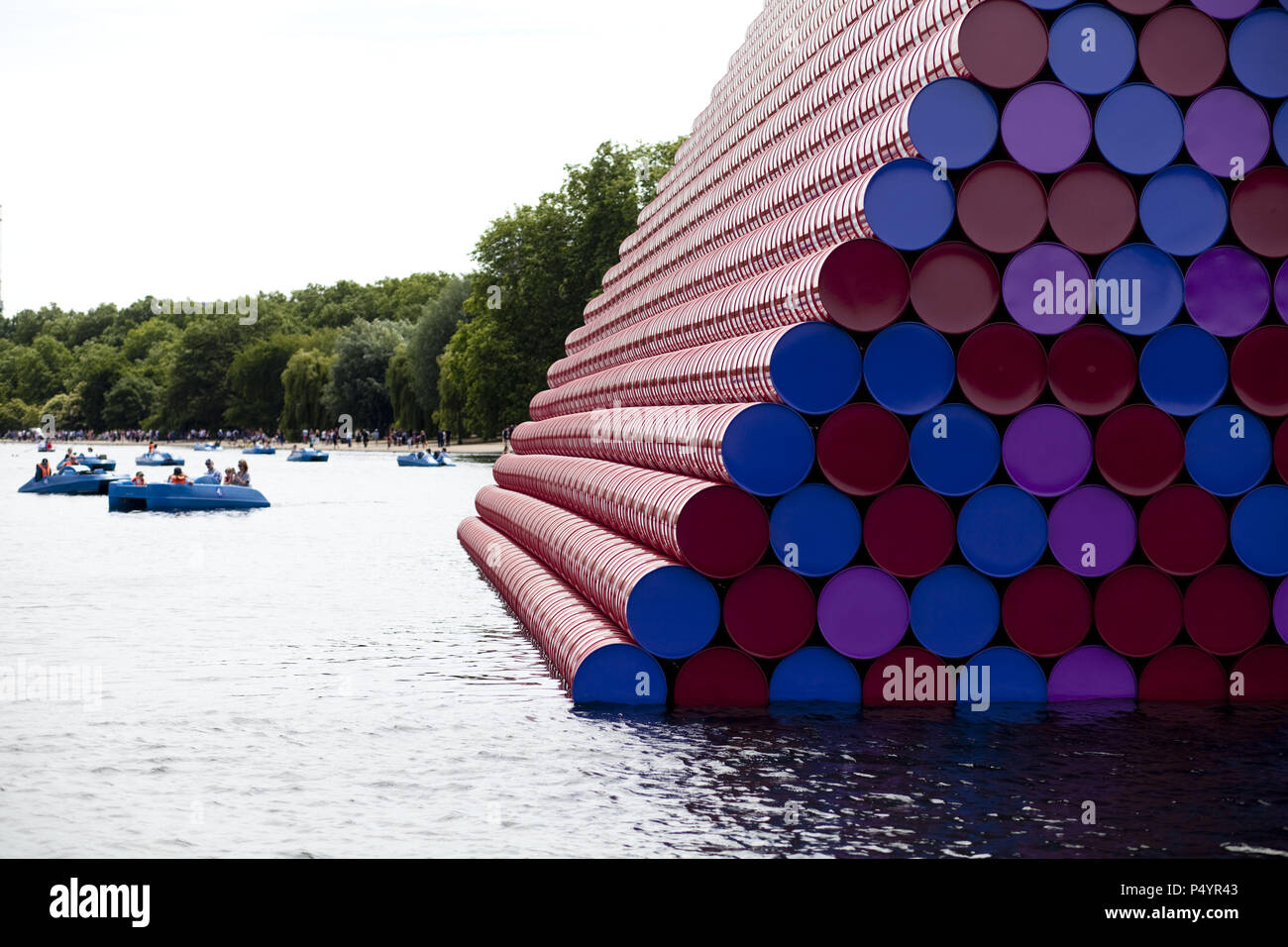 London, UK. 23 June 2018 The Mastaba, a temporary sculpture made of stacked barrels in Serpentine Lake in Hyde Park, is made by one of the world's most celebrated artists, famous for ambitious large scale works. Christo and his late wife Jean-Claude took an inspiration from ancient mastabas (benches) structures that originated in first urban civilisatons of Mesopotamia. Twenty metres in height, the structure consists of 7506 horizontally-stacked coloured barrels. The sculpture coincides with Serpentine Galleries exhibition of Christo and Jeanne-Claude's use of barrels in their work over th Cre Stock Photo