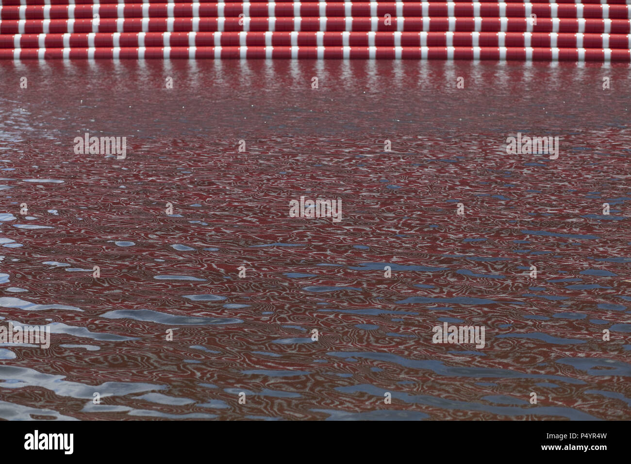 London, UK. 23 June 2018 The Mastaba, a temporary sculpture made of stacked barrels in Serpentine Lake in Hyde Park, is made by one of the world's most celebrated artists, famous for ambitious large scale works. Christo and his late wife Jean-Claude took an inspiration from ancient mastabas (benches) structures that originated in first urban civilisatons of Mesopotamia. Twenty metres in height, the structure consists of 7506 horizontally-stacked coloured barrels. The sculpture coincides with Serpentine Galleries exhibition of Christo and Jeanne-Claude's use of barrels in their work over th Cre Stock Photo