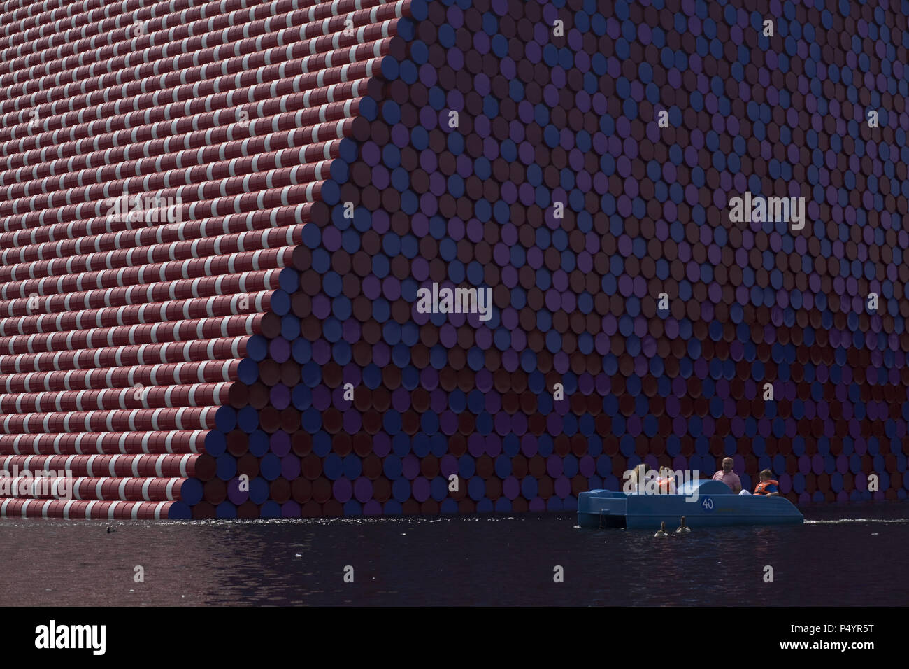 London, UK. 23 June 2018 The Mastaba, a temporary sculpture made of stacked barrels in Serpentine Lake in Hyde Park, is made by one of the world's most celebrated artists, famous for ambitious large scale works. Christo and his late wife Jean-Claude took an inspiration from ancient mastabas (benches) structures that originated in first urban civilisatons of Mesopotamia. Twenty metres in height, the structure consists of 7506 horizontally-stacked coloured barrels. The sculpture coincides with Serpentine Galleries exhibition of Christo and Jeanne-Claude's use of barrels in their work over th Cre Stock Photo