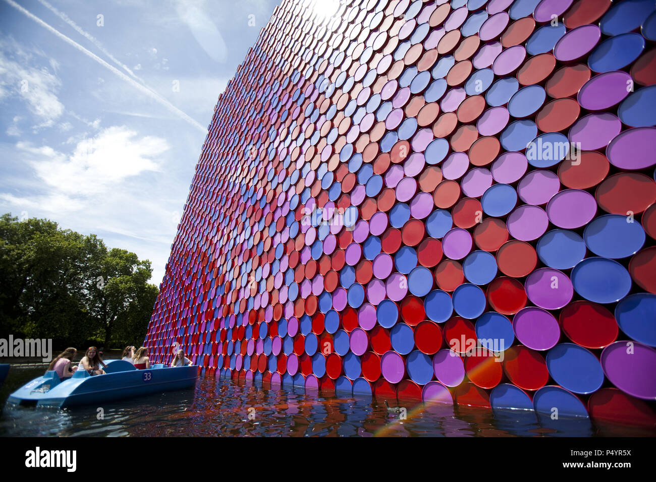 London, UK. 23 June 2018 The Mastaba, a temporary sculpture made of stacked barrels in Serpentine Lake in Hyde Park, is made by one of the world's most celebrated artists, famous for ambitious large scale works. Christo and his late wife Jean-Claude took an inspiration from ancient mastabas (benches) structures that originated in first urban civilisatons of Mesopotamia. Twenty metres in height, the structure consists of 7506 horizontally-stacked coloured barrels. The sculpture coincides with Serpentine Galleries exhibition of Christo and Jeanne-Claude's use of barrels in their work over th Cre Stock Photo