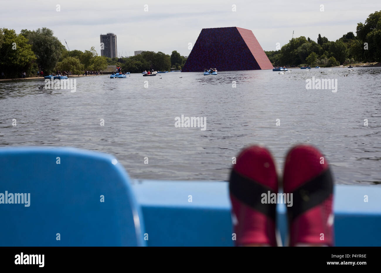 London, UK. 23 June 2018 The Mastaba, a temporary sculpture made of stacked barrels in Serpentine Lake in Hyde Park, is made by one of the world's most celebrated artists, famous for ambitious large scale works. Christo and his late wife Jean-Claude took an inspiration from ancient mastabas (benches) structures that originated in first urban civilisatons of Mesopotamia. Twenty metres in height, the structure consists of 7506 horizontally-stacked coloured barrels. The sculpture coincides with Serpentine Galleries exhibition of Christo and Jeanne-Claude's use of barrels in their work over th Cre Stock Photo