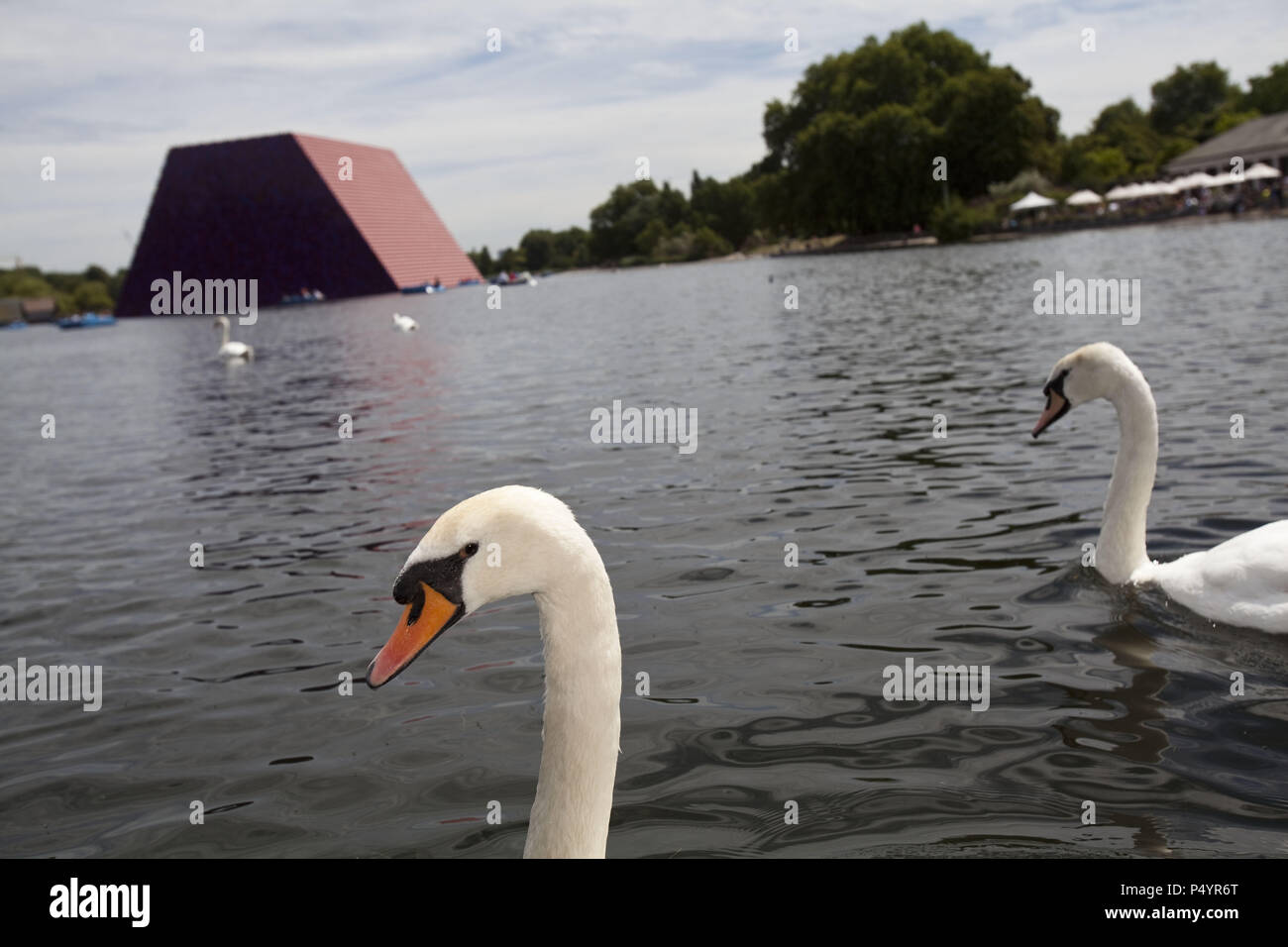 London, UK. 23 June 2018 The Mastaba, a temporary sculpture made of stacked barrels in Serpentine Lake in Hyde Park, is made by one of the world's most celebrated artists, famous for ambitious large scale works. Christo and his late wife Jean-Claude took an inspiration from ancient mastabas (benches) structures that originated in first urban civilisatons of Mesopotamia. Twenty metres in height, the structure consists of 7506 horizontally-stacked coloured barrels. The sculpture coincides with Serpentine Galleries exhibition of Christo and Jeanne-Claude's use of barrels in their work over th Cre Stock Photo