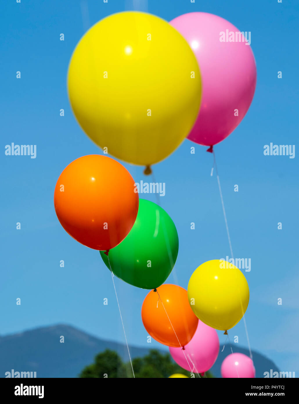 Colorful balloons; windy day; automobile dealership; Salida; Colorado; USA Stock Photo