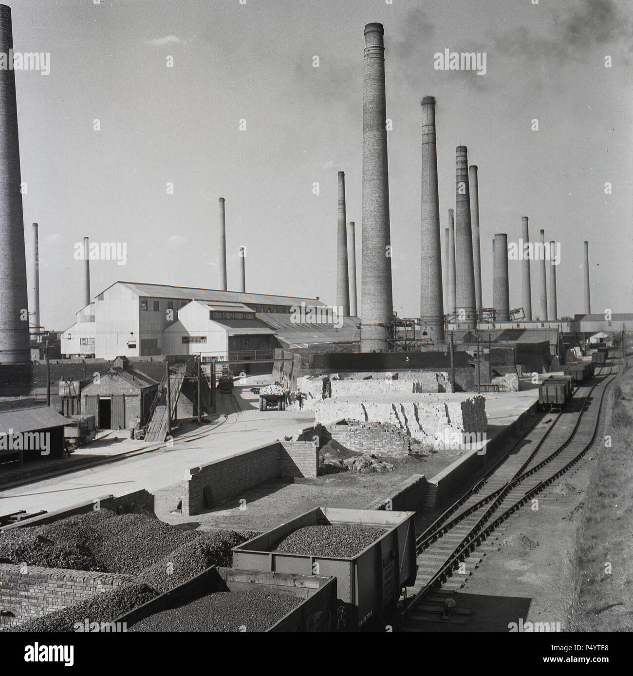 1950s, historical, Exterior view over a part of the giant brickworks of the London Brick Company at Stewartby, Bedfordshire, England, UK, showing the mass of chimneys which ventilated the numerous kilns that fired the bricks. There were as many as 162 chimneys at the site. - A British company, the London Brick Company was the largest brick producer in the world at this time, mining 'Oxford Clay', the organic mudstone or mineral that underlied parts of the South of England and which was the raw material for the famous London Brick. Stock Photo