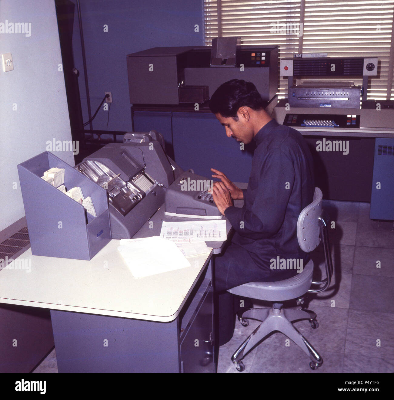 Dahran, 1965, saudi man working in the computer room at the College of Petroleum and Minerals, Saudi Arabia. The College became a universty in 1975 and in 1986 it was renamed as the King Fadh Univeristy of Petroleum and Minerals. Dahran is the headquarters of ARAMCO, the saudi government owned oil company. In 1935 the first oil well in Saudi Arabia was drilled there. Stock Photo