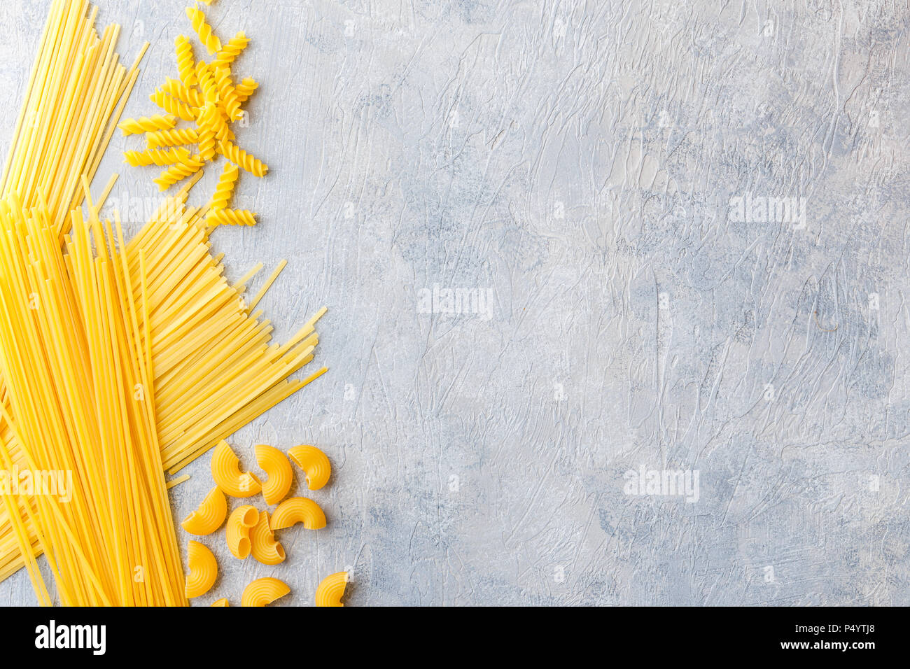 Variety of types and shapes of dry Italian pasta - Spaghetti, Linguine, Conchiglie, Elbow macaroni, Fusilli. Stock Photo