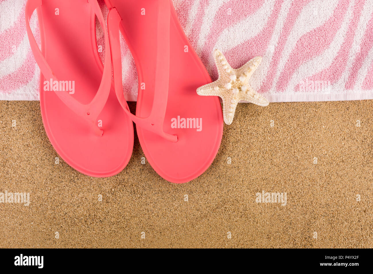 Pink sandal flip flop and towel on sand beach and starfish. Summer ...