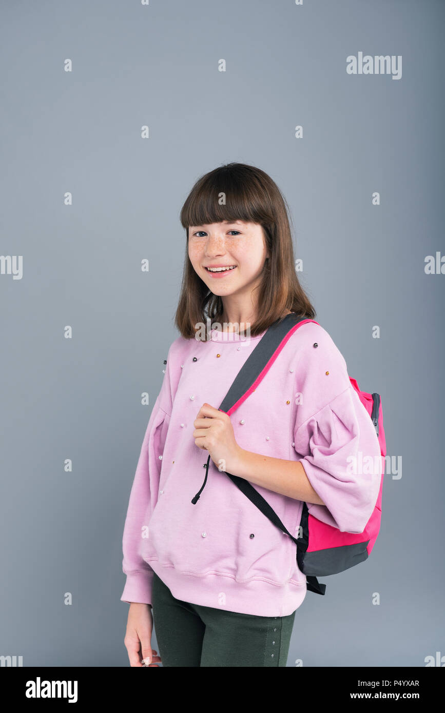 Cheerful teenage girl wearing backpack on her shoulder Stock Photo - Alamy