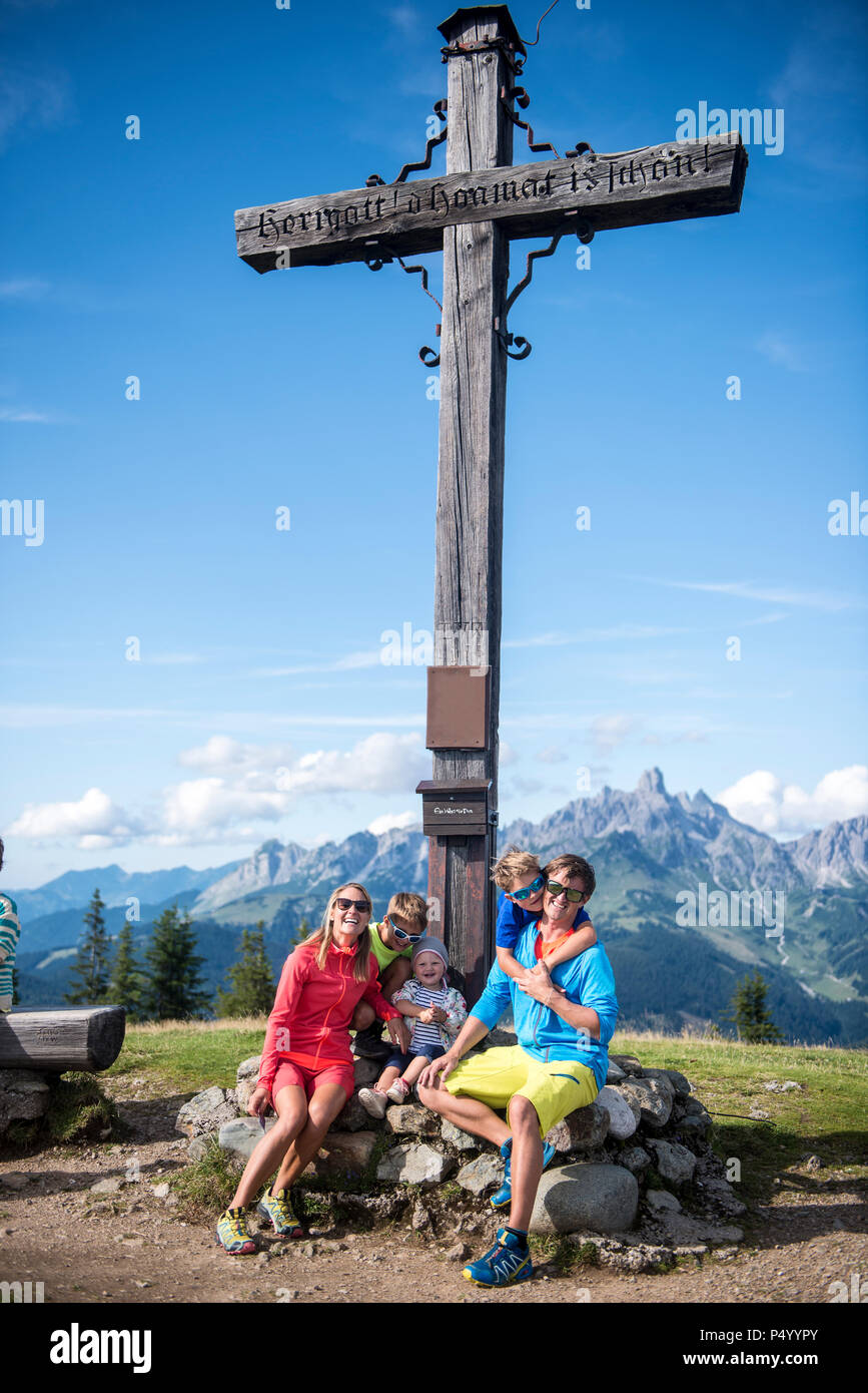 Austria, Salzburg State, Untertauern, family sitting at summit cross Stock Photo