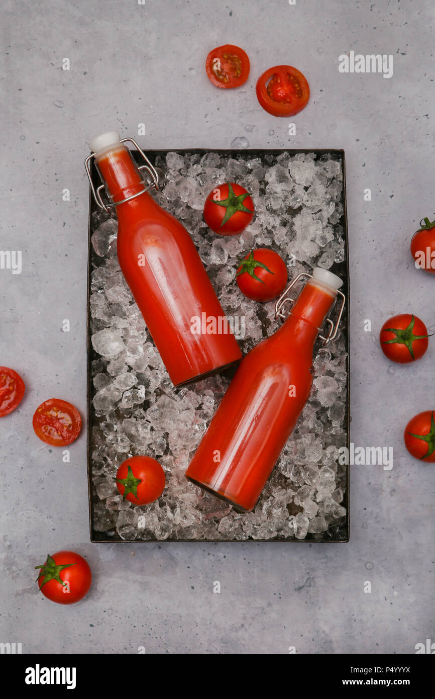 Ice-cooled homemade tomato juice in swing top bottles Stock Photo