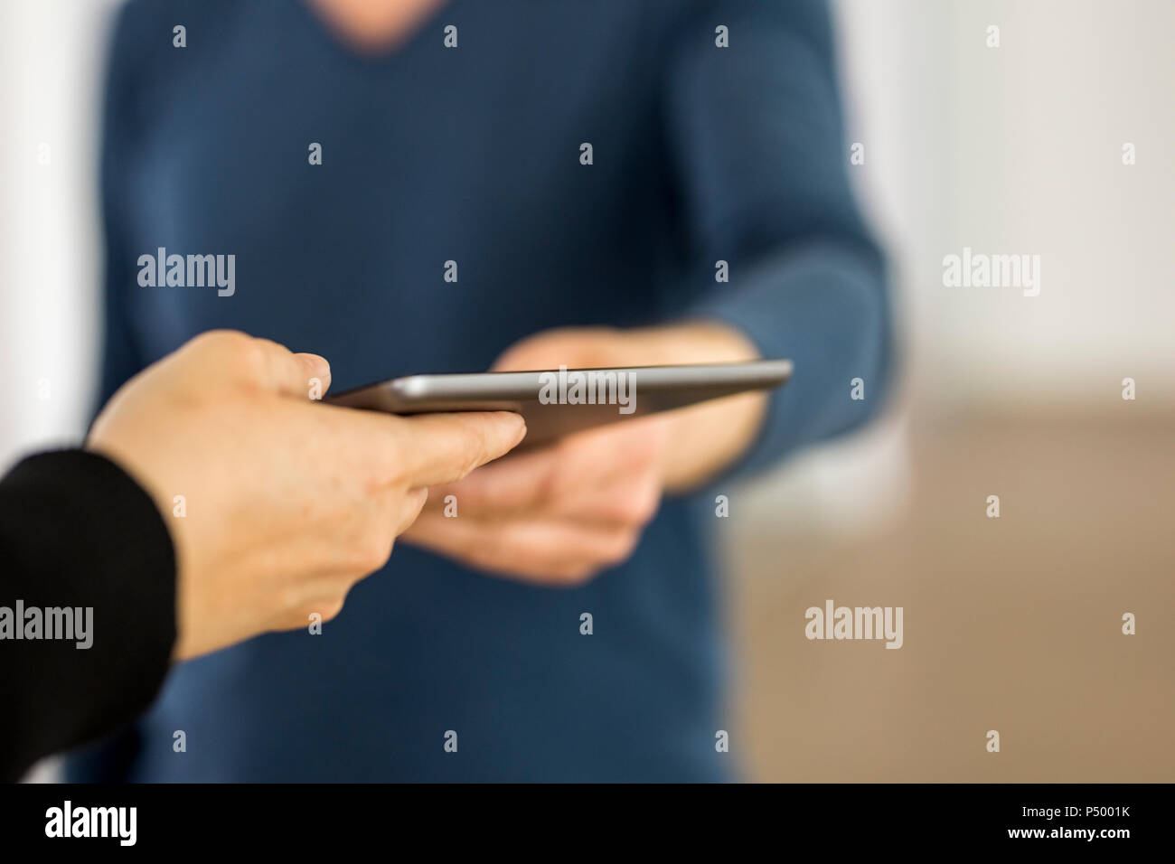 Hands of a man and a woman holding digital tablet Stock Photo