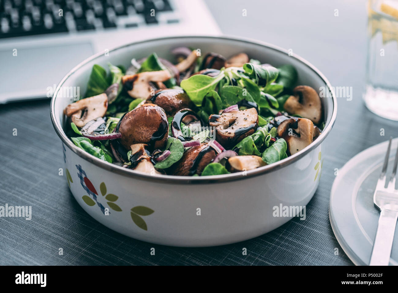 Lunch box with field salad, onions, roasted mushrooms, onions and balsamico Stock Photo