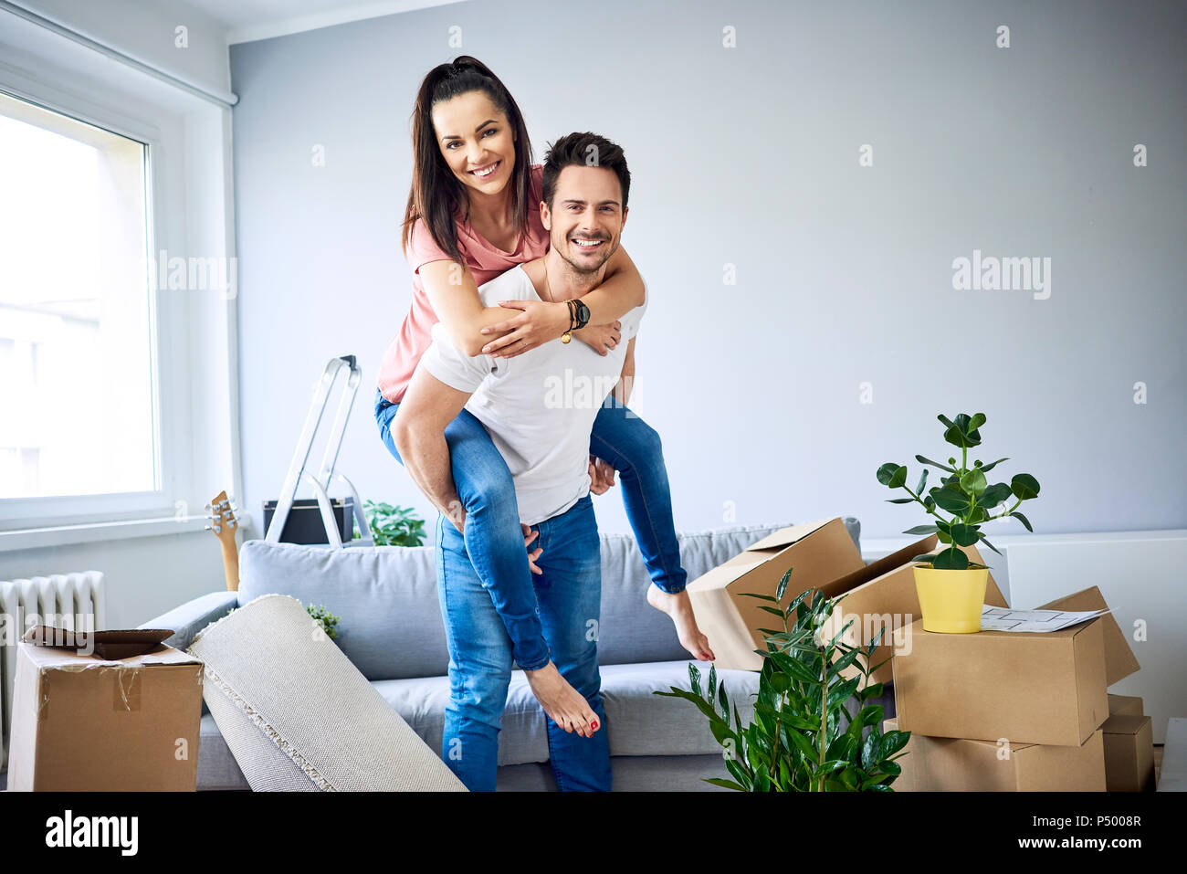 Portrait of cheerful couple moving in Stock Photo