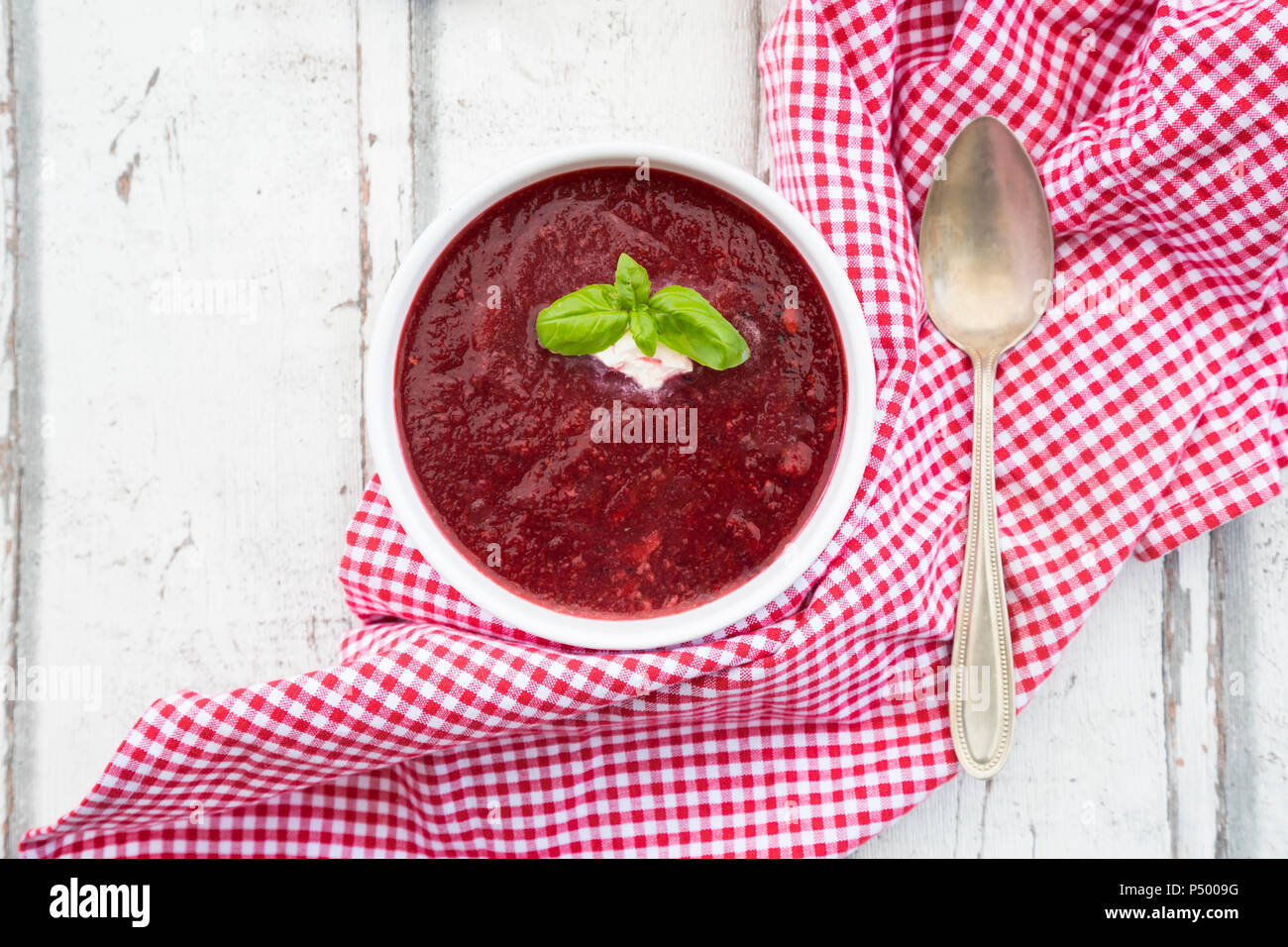 Beetroot soup in bowl on white wood Stock Photo