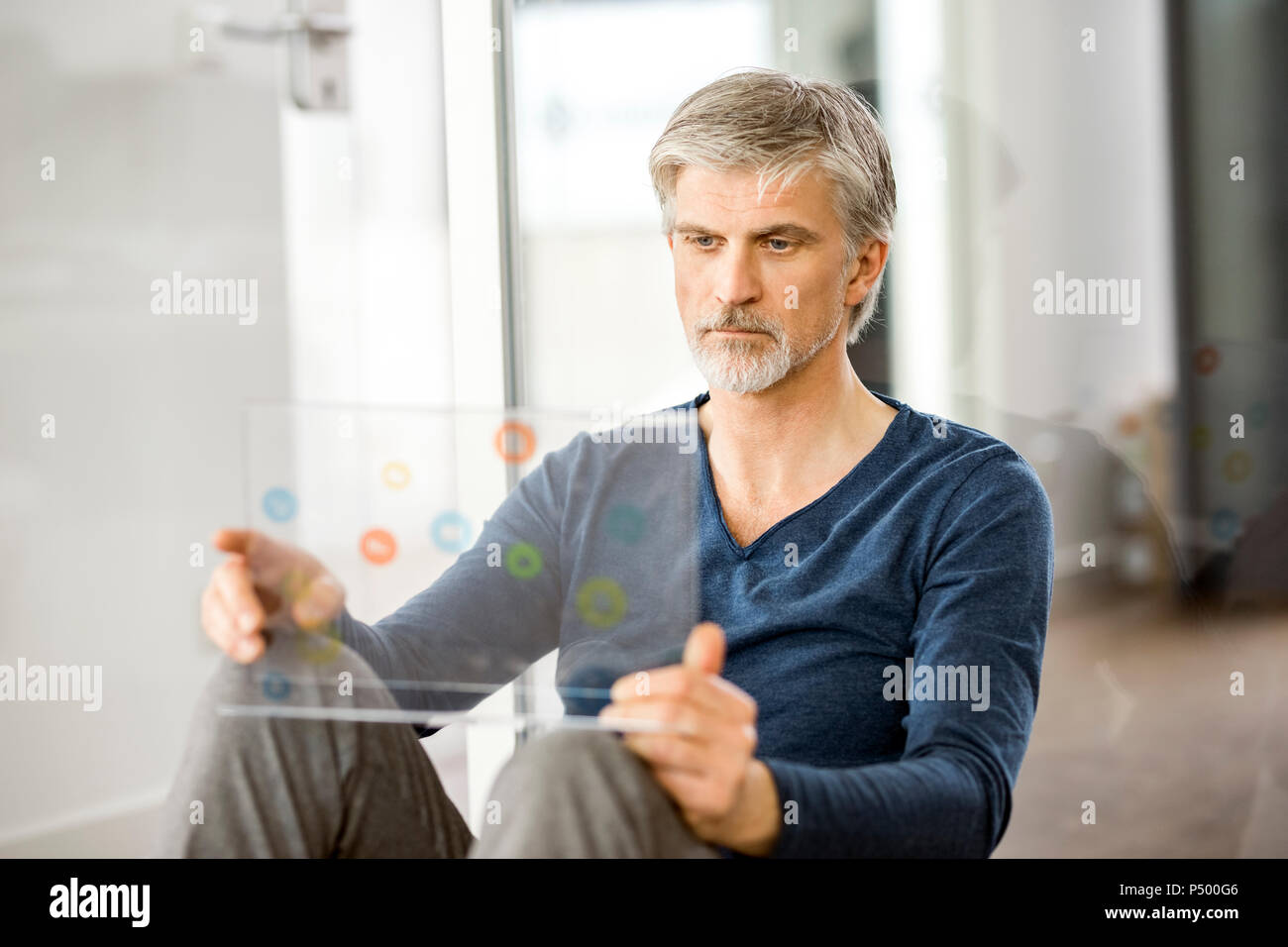Mature businessman using transparent touchscreen computer Stock Photo