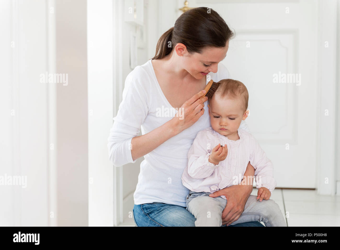 Mother brushing baby's hair at home Stock Photo Alamy