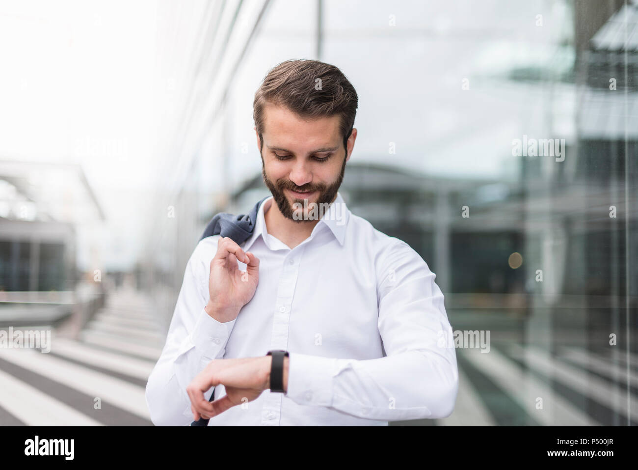Smiling young businessman checking the time Stock Photo
