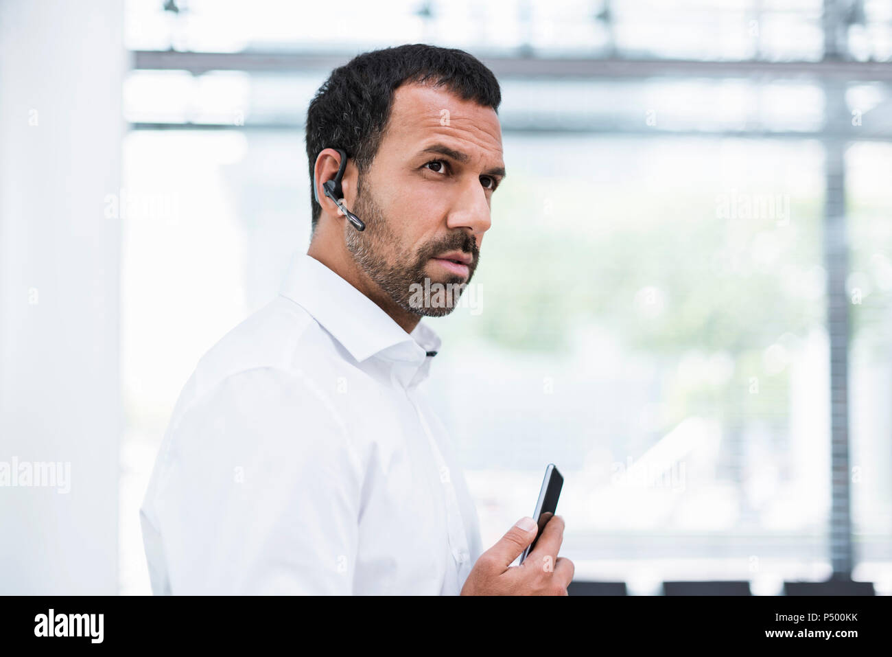 Businessman using smartphone and headset Stock Photo