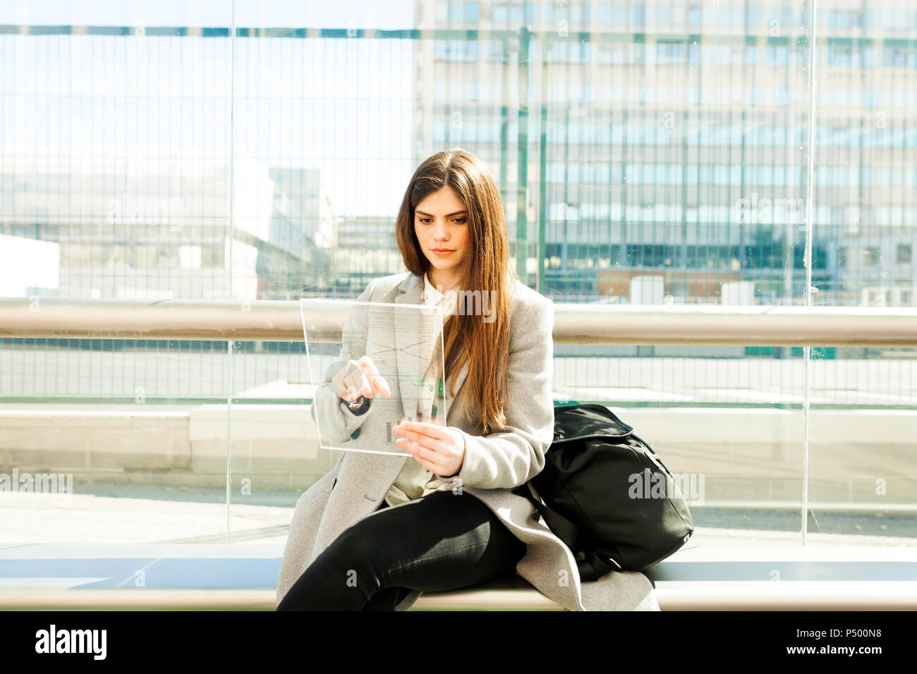Spain, Barcelona, portrait of young businesswoman using futuristic portable device at station Stock Photo