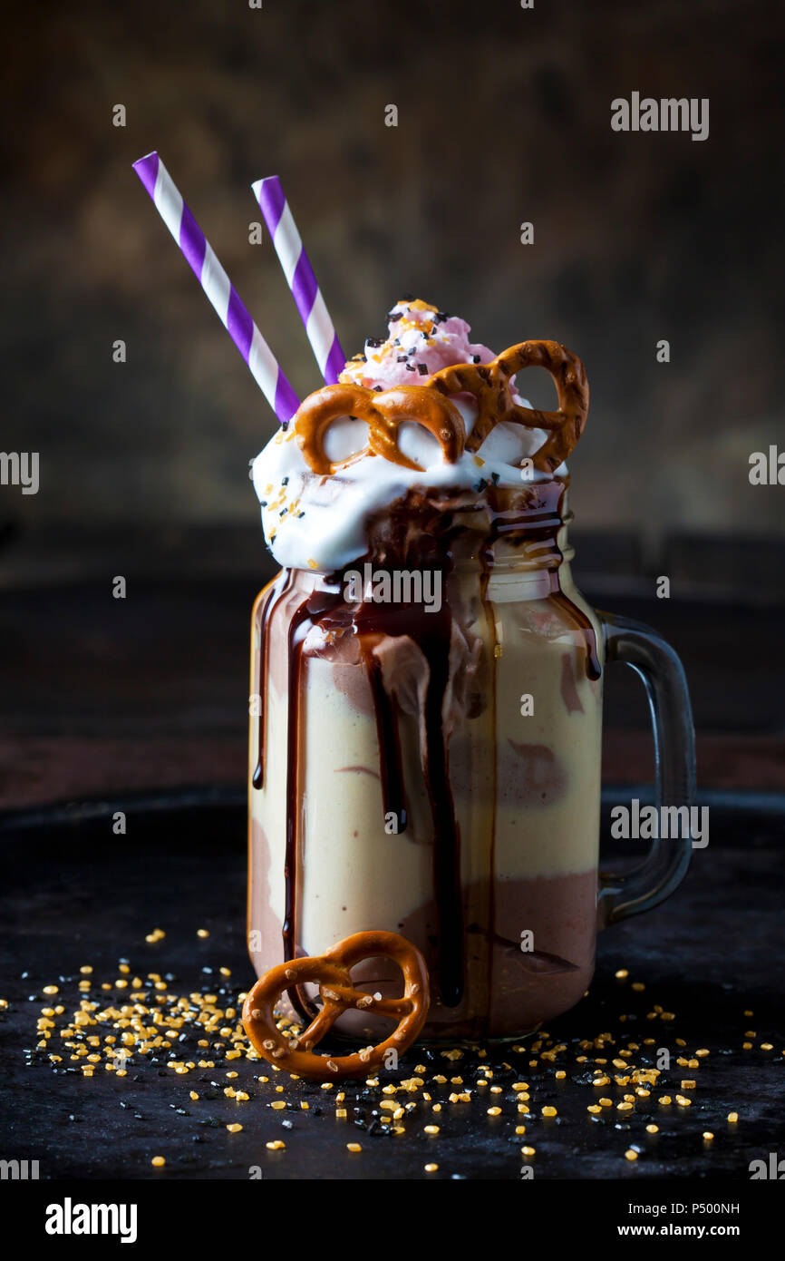 Glass of vanilla milkshake with cacao, chocolate sauce, whipped cream and topping Stock Photo
