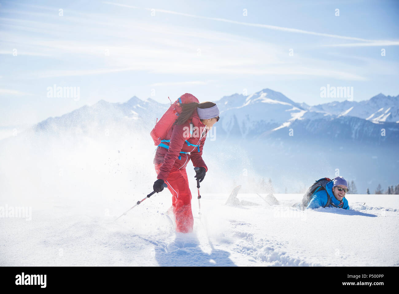 Austria, Tyrol, snowshoe hikers running through snow, man falling Stock Photo