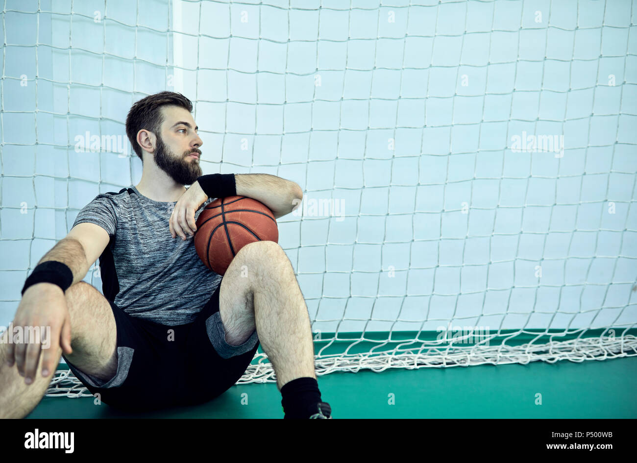 Man with basketball during break, indoor Stock Photo