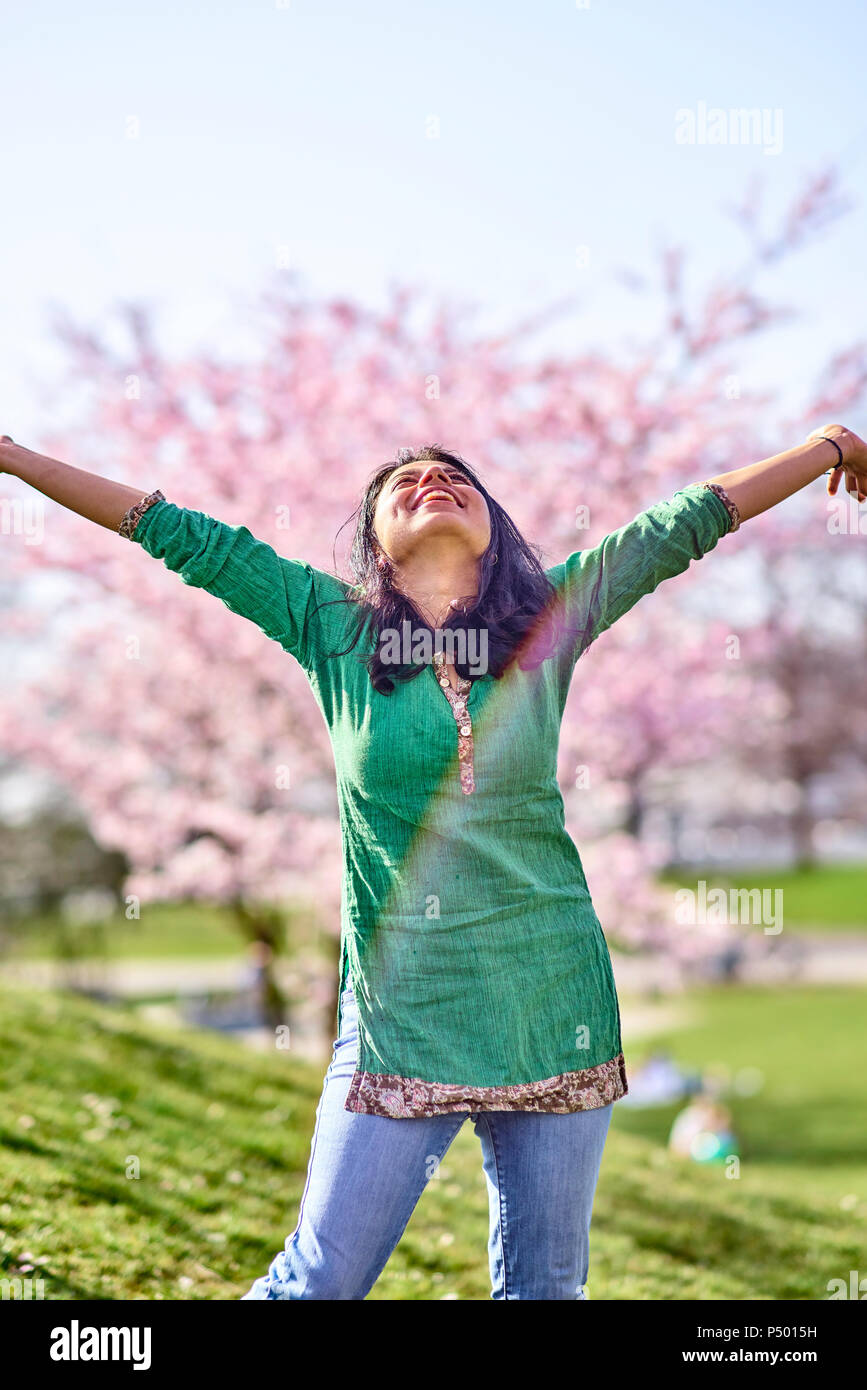 Happy young woman in a park at cherry blossom tree Stock Photo - Alamy