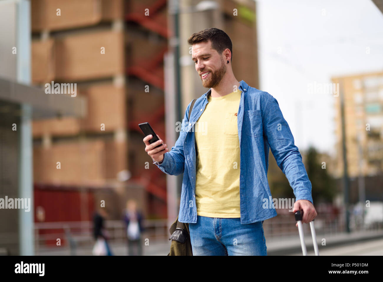 Young man with smartphone at station Stock Photo