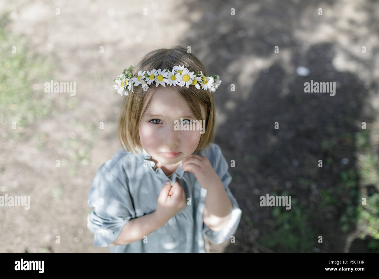 Portrait of blond little girl wearing flowers Stock Photo