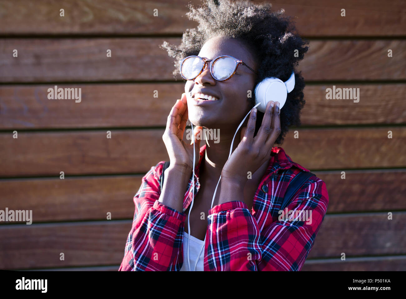 Portrait of smiling young woman listening music with headphones Stock Photo