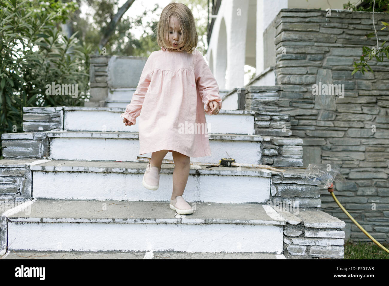 Little girl walking downstairs Stock Photo