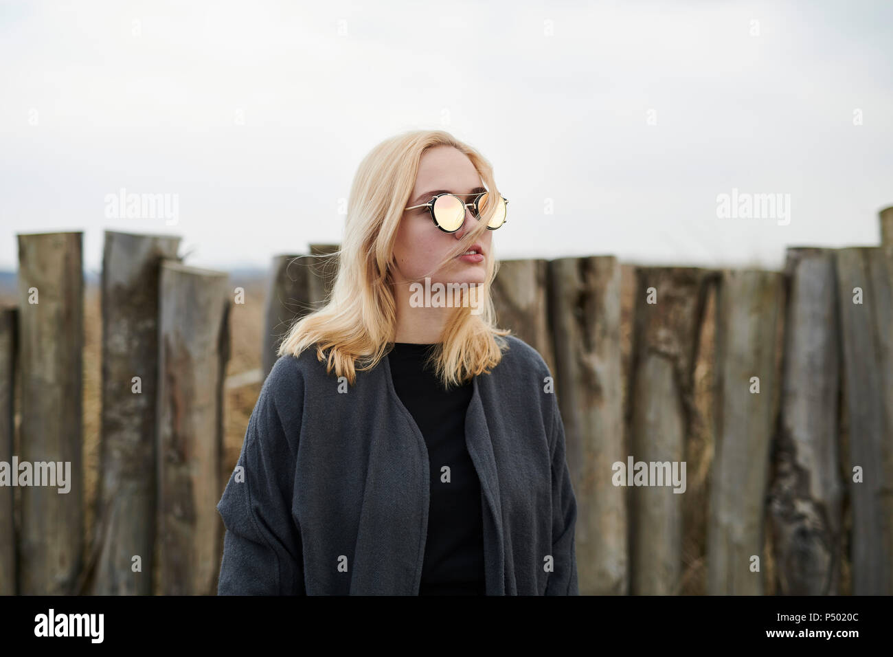 Portrait of blond young woman wearing mirrored sunglasses on the beach Stock Photo