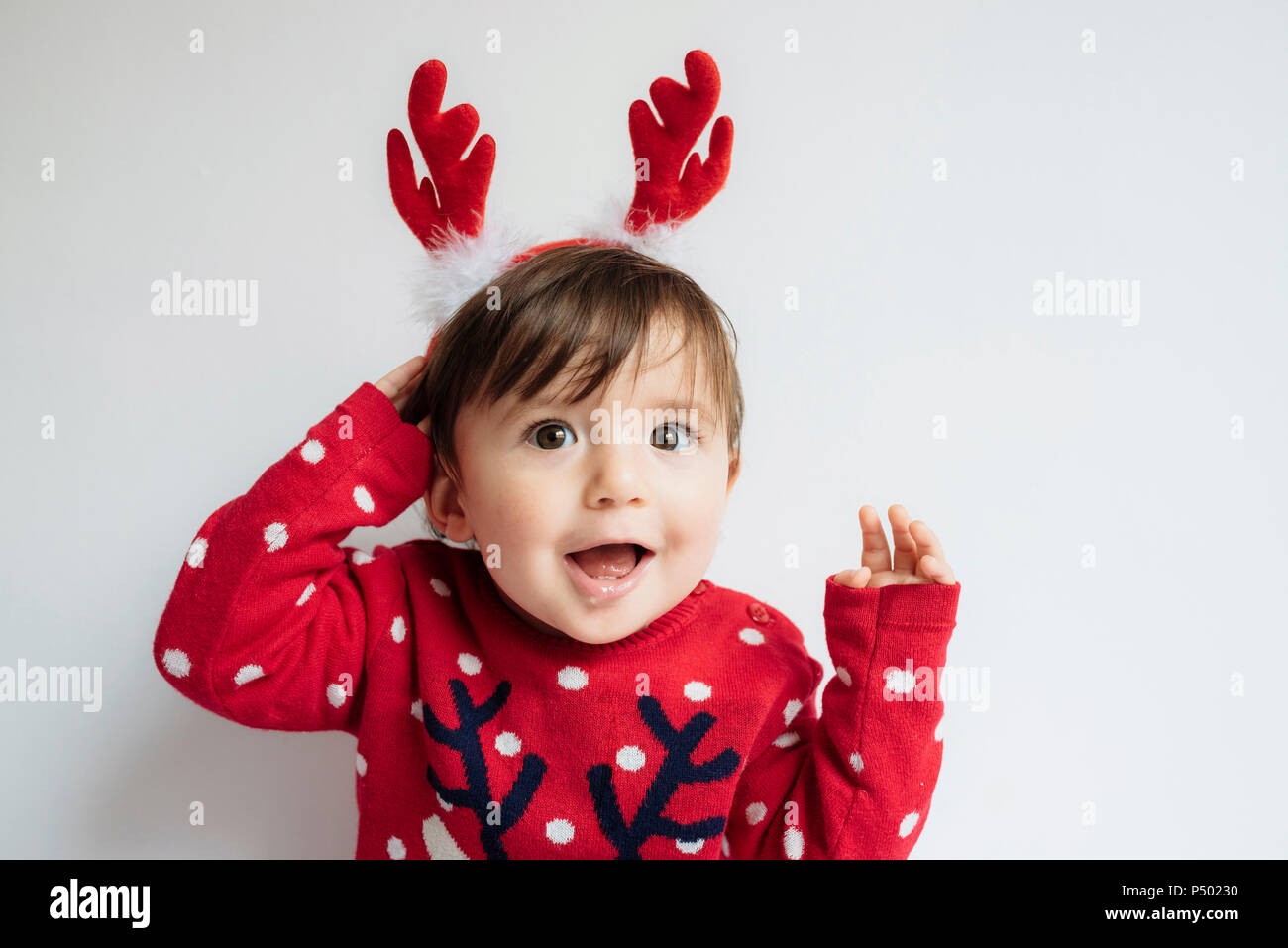 Portrait of baby girl with reindeer antlers headband at Christmas time Stock Photo