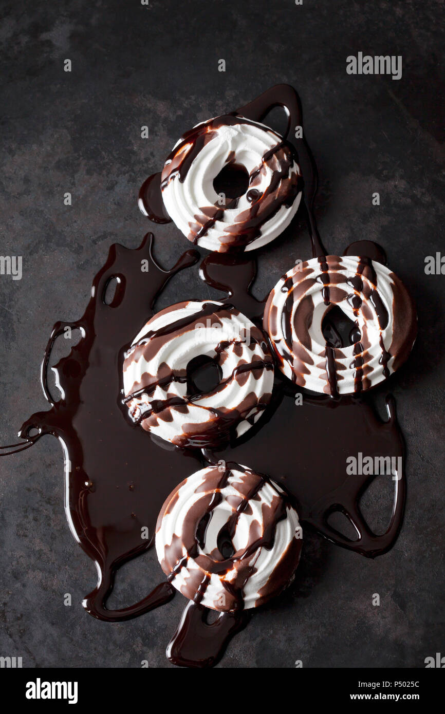 Four meringue pastries with chocolate sauce Stock Photo