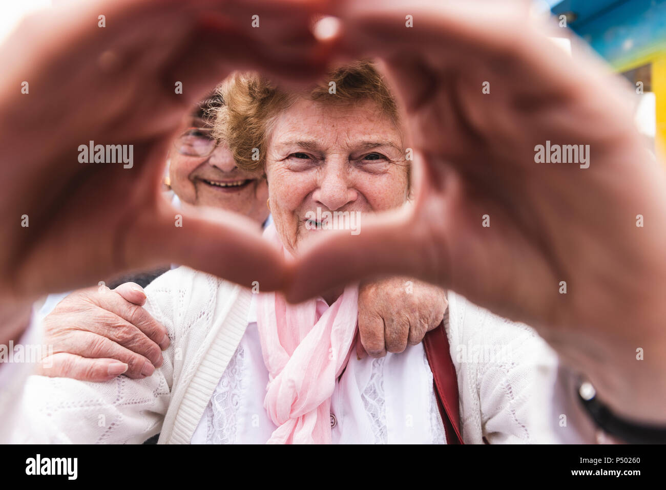 Portrait of happy senior woman shaping heart with her hands Stock Photo