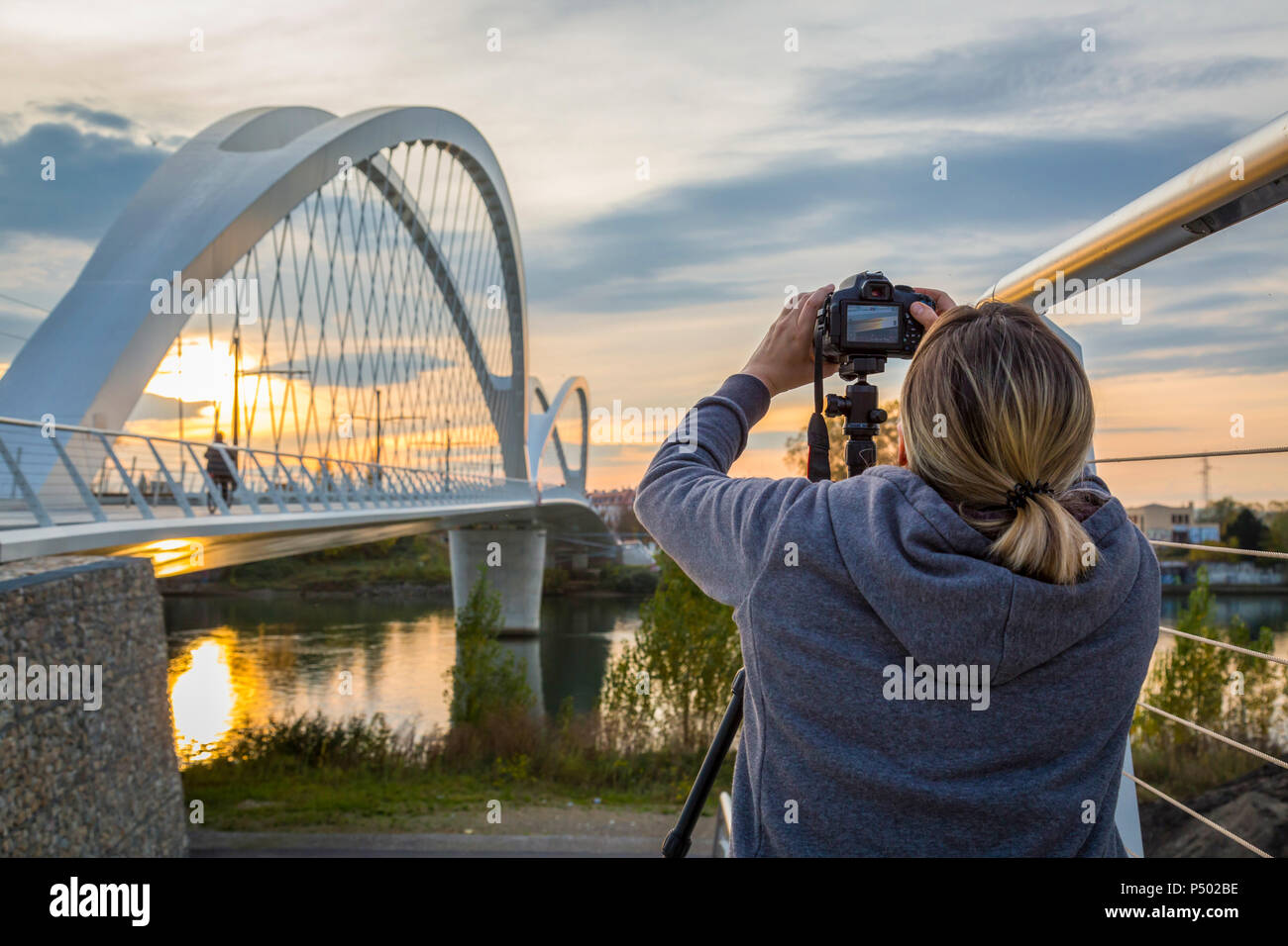 France, Alsace, Strasbourg, Passerelle des Deux Rives at sunset, female photographer in the foreground Stock Photo