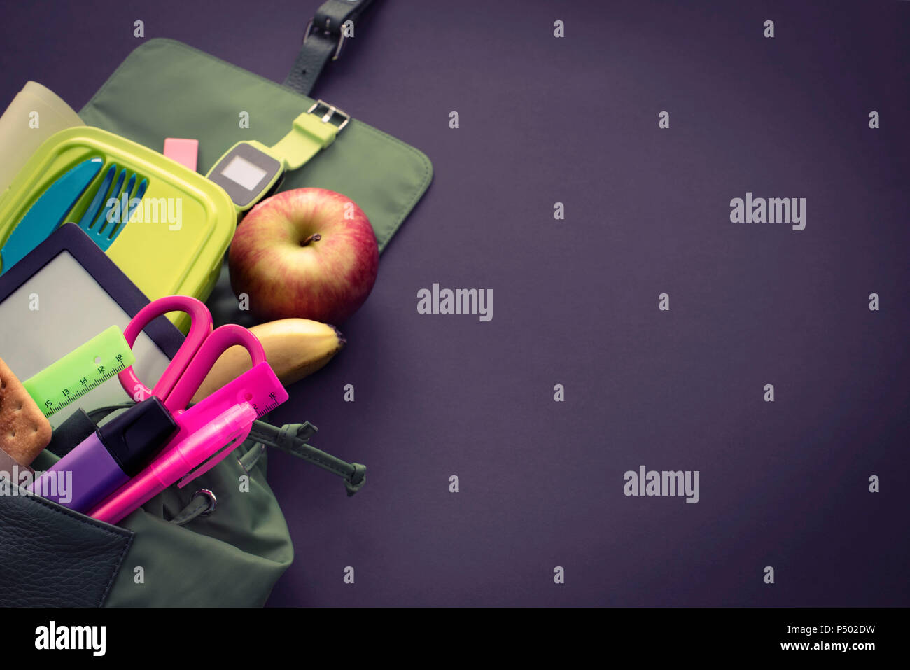 Backpack with school supplies on black background. Top view Flat lay Stock Photo