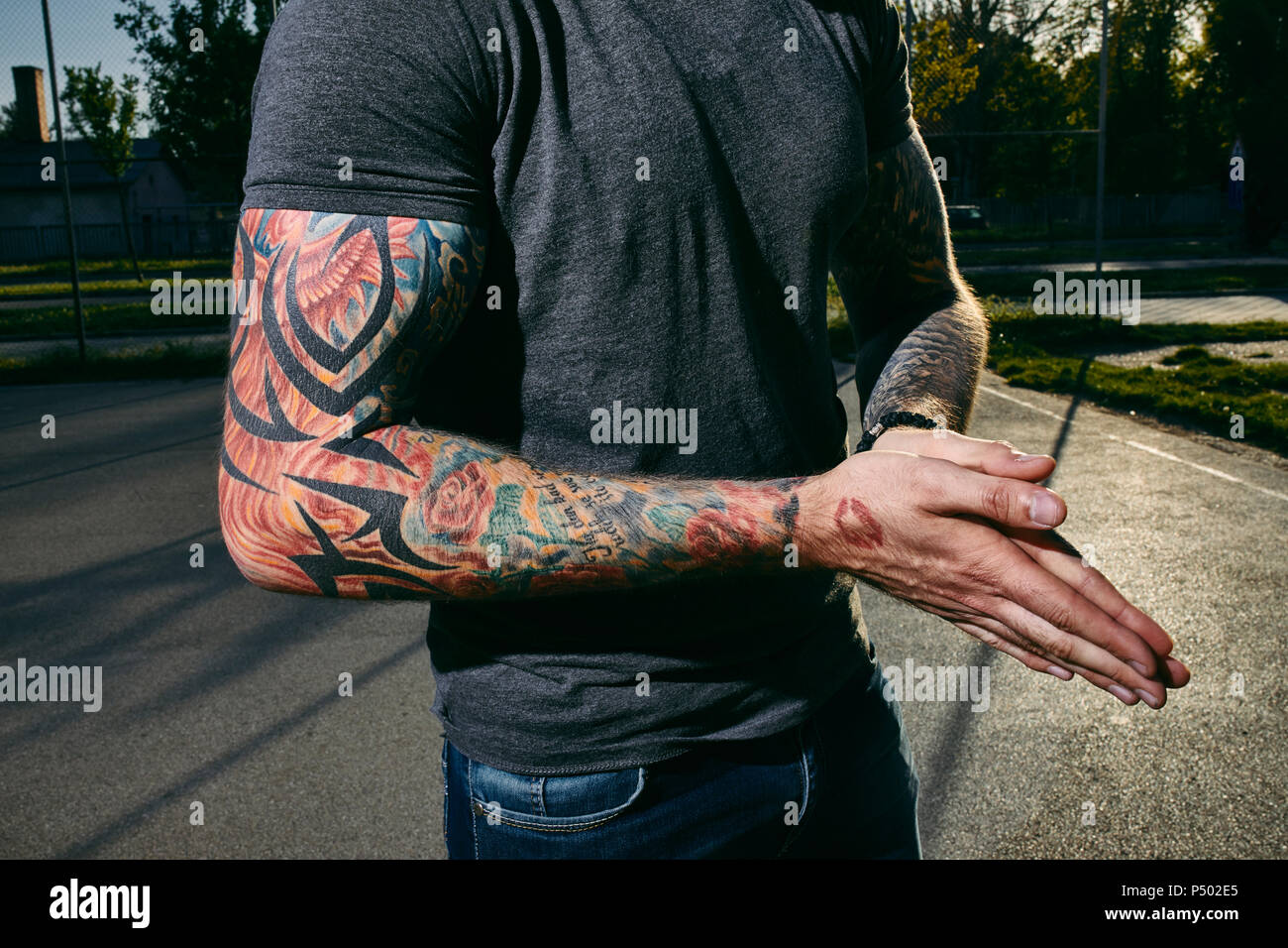 Tattooed arms of a young man outdoors Stock Photo