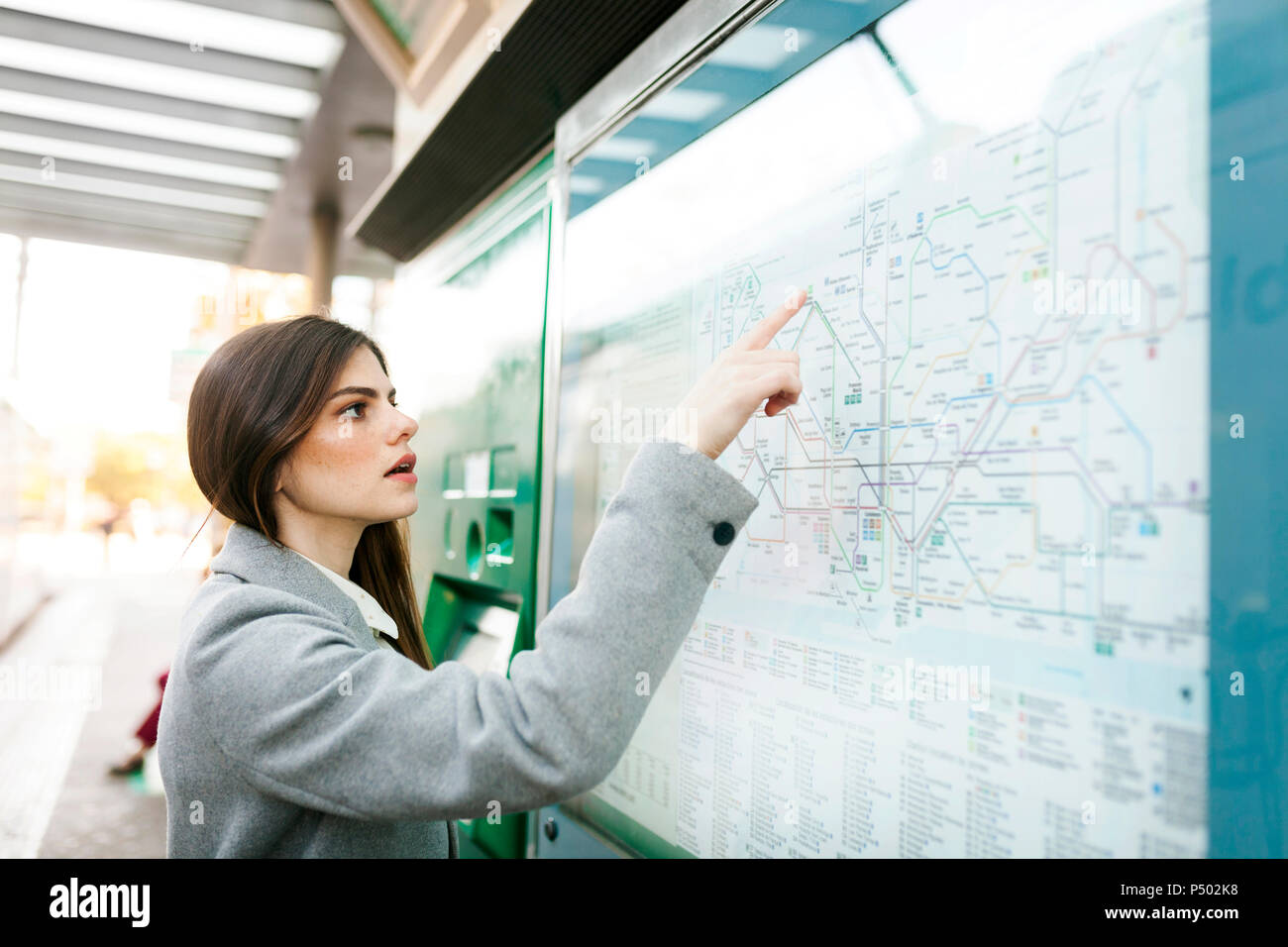 Spain, Barcelona, young woman looking at map at station Stock Photo