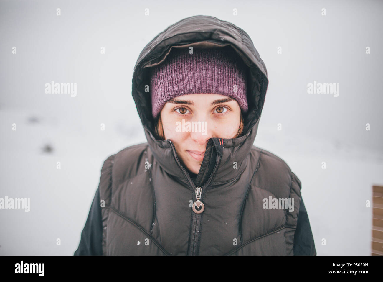 Austria, Kitzbuehel, portrait of smiling young woman in winter Stock Photo