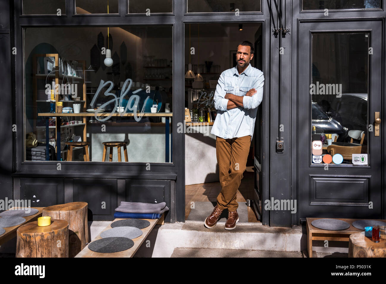 Man standing at entrance door of a cafe Stock Photo - Alamy