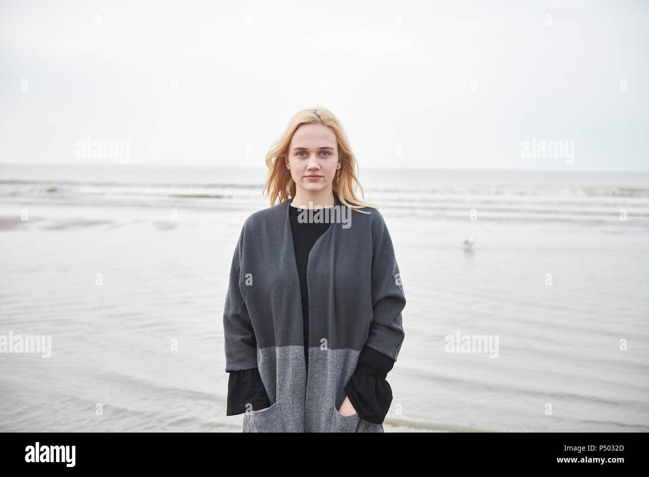 Netherlands, portrait of blond young woman on the beach Stock Photo