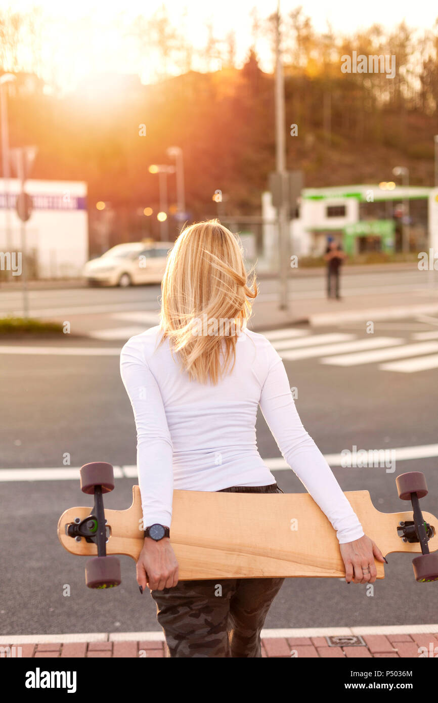 Back view of blond woman with longboard Stock Photo