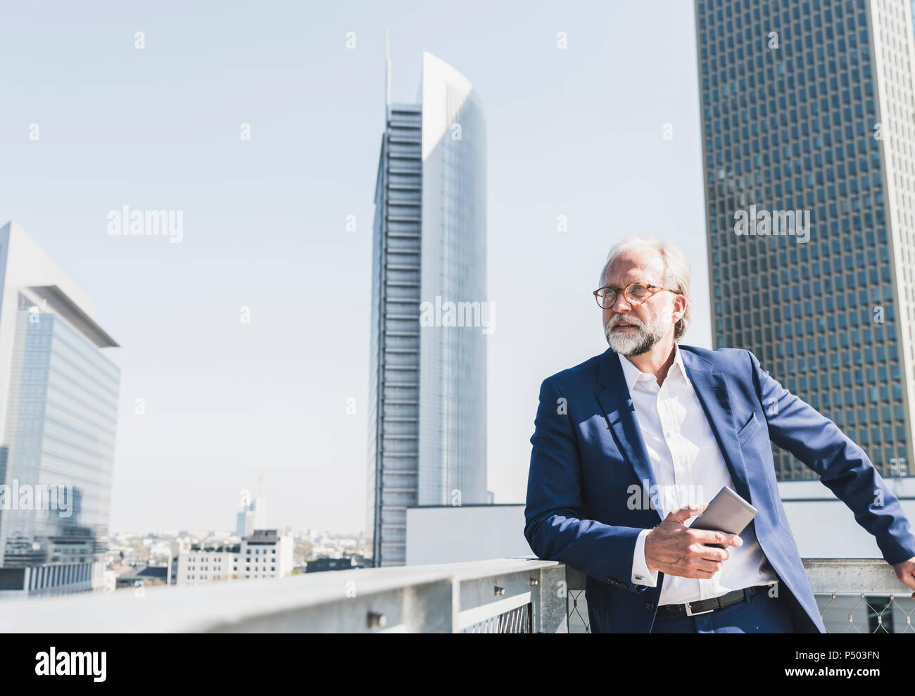 Mature businessman with cell phone in the city looking around Stock ...